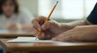 © DAVA - Close-up of hands writing on test paper in classroom
