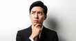 © Komeng - Contemplative Asian Businessman in Suit Ponders a Solution.