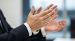© Mohammad - A person in a suit is clapping their hands in what appears to be an office environment setting area