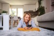 © Jelena - Smiling Woman Relaxing on Carpet Using Smartphone at Home