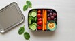 © Роман Соловьев - Sustainable nutrition concept with stainless steel lunch box and plant-based food overhead