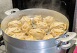 © Dmitry Presnyakov - Delicious Manty, posture, khinkali is prepared in a special pot - mantoverde. Dishes of Asian, Buryat, Georgian cuisine. Aluminum steamer for cooking mantas on a stove in a home kitchen. Meat food.