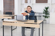 © New Africa - Young businessman stretching his arms at table in office