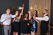© New Africa - Friends celebrating New Year with sparklers and wine glasses indoors