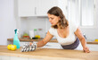 © JackF - Portrait of female houseworker dusting kitchen surfaces indoors
