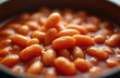 © Viktor - Close-up of orange baked beans in thick red tomato sauce. Delicious healthy vegetarian dish. Nutritious food ready to eat for breakfast lunch or dinner. Classic English meal, simple diet.
