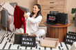 © Pixel-Shot - Young woman with new clothes sitting on floor at home. Black Friday sale