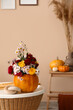 © Pixel-Shot - Pumpkin with beautiful autumn flowers on table in interior of living room, closeup