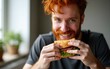 © zhao - Redhead man enjoying while eating sandwich in the morning at home. High quality
