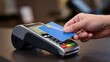 © Julia - Checkout retail. Man's hand taps a blue credit card on a payment terminal at a store counter.