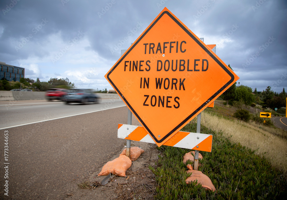 Orange traffic sign stating Traffic Fines Doubled in Work Zones with ...
