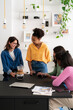 © Studio Marmellata - Four diverse young women are enjoying coffee and conversation around a table. They are smiling and sharing a pleasant moment together in a bright room.