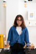 © Studio Marmellata - A young woman with glasses stands in her modern kitchen, looking at the camera. She has just brewed coffee using a pour-over method, with a glass of coffee nearby.
