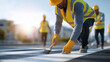 © Tania - A group of construction workers wearing reflective vests and helmets while applying safety symbols and pedestrian crossings, showcasing teamwork, workplace safety, organization, and attention to