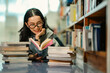 © Wanwajee - A portrait image conveying the emotion of relaxed reading in a library setting filled with bookshelves. It represents calmness, silence, and the commitment to lifelong learning.