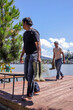 © Queenmoonlite Studio - Barefoot Fishermen Walking on Dock With Rubber Boots on Beautiful Sunny Day Near Lake