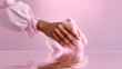 © Nataliia_Trushchenko - Hand holding a pink cloth, gently wiping a reflective surface, with soft pink background creating a serene atmosphere, showcasing cleaning action and attention to detail in a minimalist setting