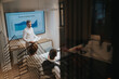 © qunica.com - A professional presenter in a white shirt stands beside a screen displaying a results chart while colleagues listen and take notes in a modern conference room.