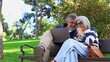 © luisrojasstock - Senior couple using laptop laughing together in park