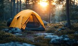 Yellow tent illuminated by golden sun flare in a tranquil wild forest setting among pine trees and rocks, symbolizing outdoor adventure, travel, and camping lifestyle.