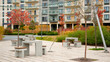 © khmelev - modern urban courtyard scene features concrete benches and autumn trees near apartment buildings. inviting outdoor space ideal for relaxation and community gatherings, with string lights creating