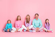 © deagreez - Family gathering with parents and children smiling together in pastel pink studio for love joy and warm togetherness