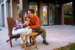 © DusanJelicic - Smiling young couple embracing on their home terrace, enjoying a moment of connection and using a mobile phone, representing a tranquil domestic lifestyle in autumn