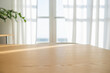 © Macrostock - Empty wooden table against blurred window with curtain and green pant branch background