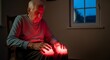 © Qory - An elderly man sits, his hands touching knees glowing red, likely due to a health issue