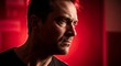 © Qory - A man stares intently, lit dramatically by red light. His expression reveals intensity