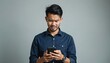 © Maryna - Young Asian man looks irritated by text message on smartphone. Guy wears navy shirt, holding mobile phone, showing upset facial expression and negative emotion.