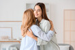 © Pixel-Shot - Pretty young woman hugging her mother at home. International Hug Day