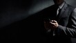 © Jojo* - Figure in dark suit leans against a textured wall while engaging with a handheld communication device