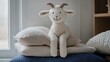 © Robert - Stuffed goat with a stitched smile leaning on a stack of pillows