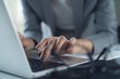 © tippapatt - Closeup of businesswoman hand typing on laptop computer at office. Business woman busy working on computer, searching the information, surfing the internet on table at workplace