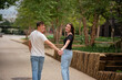 © Cavan - Millenial Couple Hold Hands and Walk in Urban Park