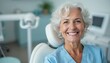 © Vadym - Elderly woman sits in dental chair, smiling with perfect white teeth after treatment. She looks happy and healthy, showing good oral care results. Dentist appointment completed, patient satisfied.