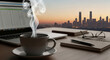 © mdshafikul - Steaming coffee cup on desk with laptop and cityscape at sunrise