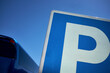 © TrueFrame Collective - Parking traffic sign and modern blue tourist coach against sunny cloudless sky, close-up shot