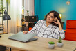 © Andrii Iemelianenko - Indian woman at home closes laptop breaths deep relief happy project finished welcomes relaxation. Arabian girl at table leans back enjoys calm moment savoring big success resting at desk after effort