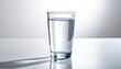© elviana - Clear Glass of Water with Tiny Bubbles Reflecting Light Against a White Background