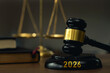 © Pcess609 - Close up judges gavel with gold band on a base engraved 2026, with blurred justice scales and a law book. Symbolizes law, court judgment, legal reform, governance, and the future justice system.