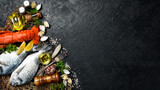 Many different fresh seafood: Fish, clams, crustaceans, lobster and octopus on slate black table. Free space for text or design.