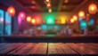 © Pete - Empty wooden table top in dark bar setting. Blurred background colorful lights, glowing bokeh. Night club party atmosphere with space for product display text overlay. Vibrant nightlife scene.