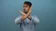 © Krakenimages.com - Young hispanic man isolated against blue background making a stop gesture with serious expression, conveying a strong message, wearing casual shirt