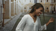 © Krakenimages.com - African american woman dancing and smiling on an old town street with braided hair and loose white blouse; joy freedom movement.