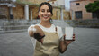 © Krakenimages.com - Woman waitress in apron points finger to camera while holding notepad and pen on outdoor stone steps near building; friendly welcome service.