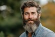 © fatman - Smiling bearded father stands outdoors in nature with vibrant greenery and a subtle autumn backdrop during a sunny day, celebrating family moments and happiness