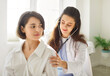 © Studio Romantic - Woman doctor doing medical exam with stethoscope. Beautiful young female physician puts stethoscope to back of young woman patient for lungs and breathing diagnostic checkup