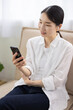 © hidez - Smiling Woman Using Smartphone with Wireless Earphones
